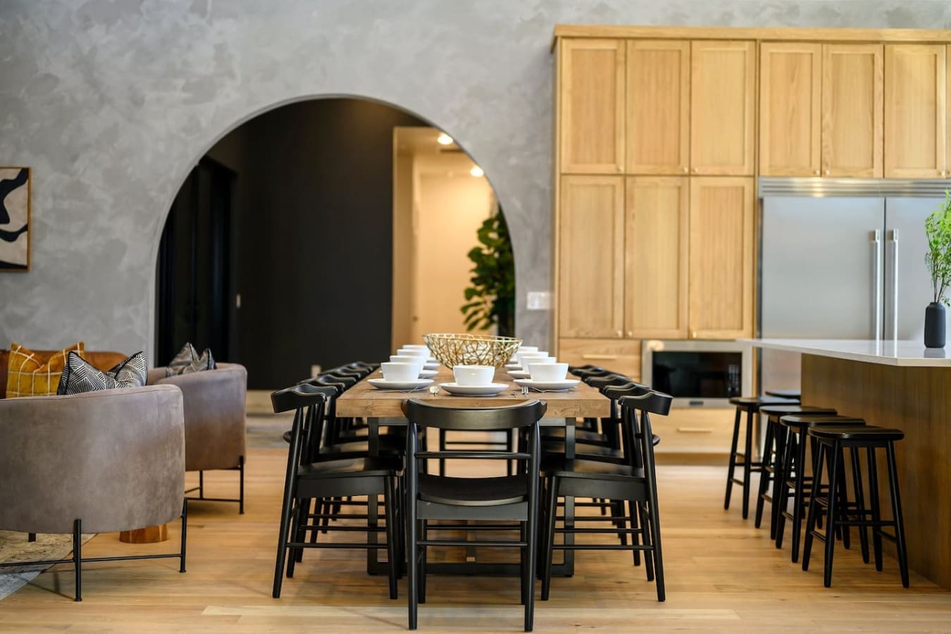 This open-concept dining and living space feels like the perfect setup for gathering everyone together, with that stunning arched doorway connecting the rooms and natural wood throughout creating this warm, inviting vibe.