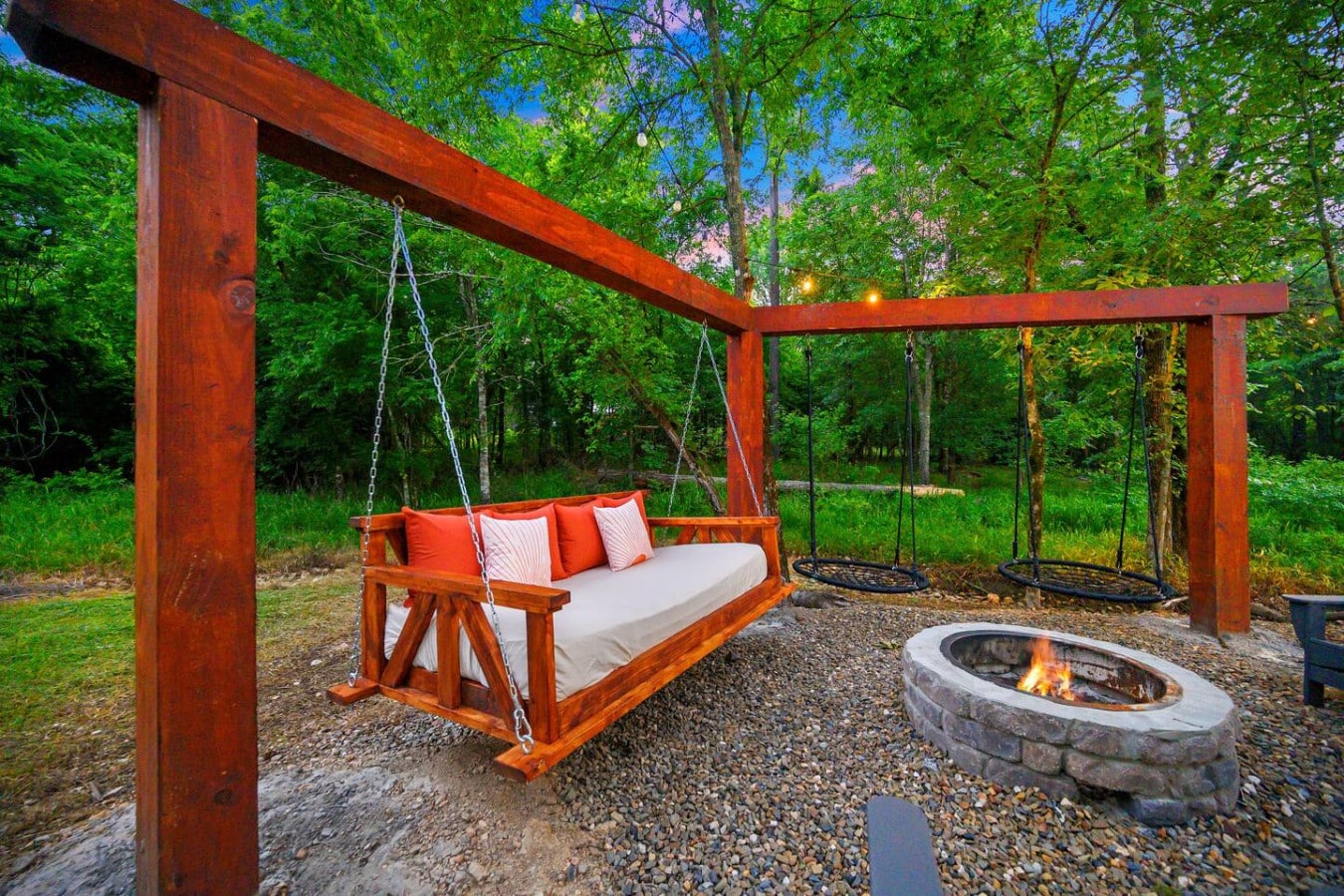 Sway into serenityu2014nothing beats cozying up by the fire on this dreamy swing under the trees.