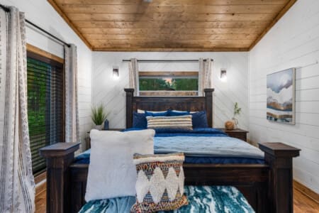 Wake up to the sound of birds chirping and the gentle rustle of leaves in our cozy cabin bedroom.