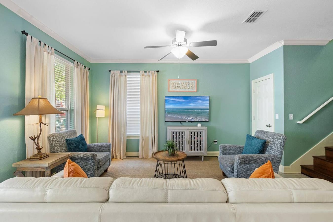 This mint-green sanctuary is basically the ultimate chill-out zone where the TV shows you the beach, the chairs invite you to stay awhile, and that ceiling fan keeps the good vibes flowing.