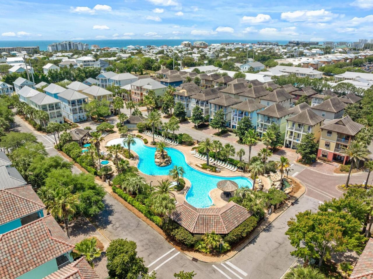 Take a dip in the community pool and you'll understand why everyone here can't stop smiling—the beach is literally right there beyond those rooftops.