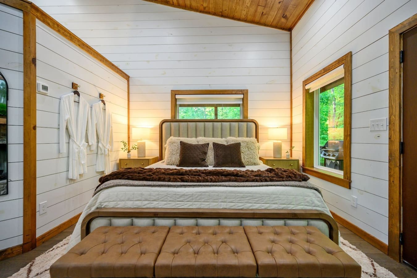 Wake up in this wood-framed bedroom with those massive windows flooding in forest views, and you'll forget that the outside world even exists.