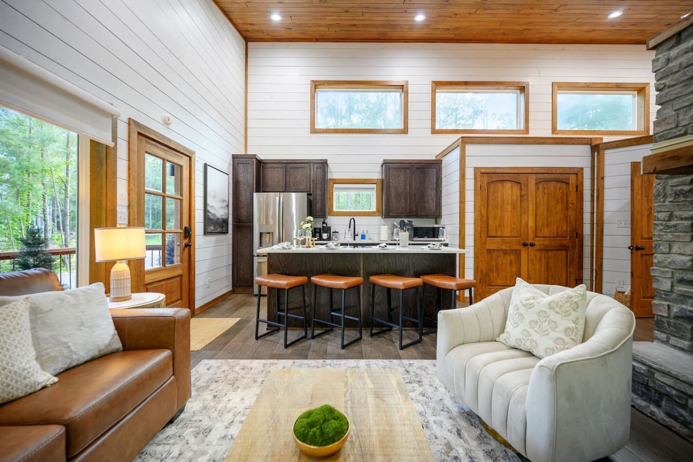 This open-concept living space is basically the heart of the cabin—kitchen, dining, lounge, and those killer forest views all flowing together so naturally that you'll never want to cook or hang out anywhere else.