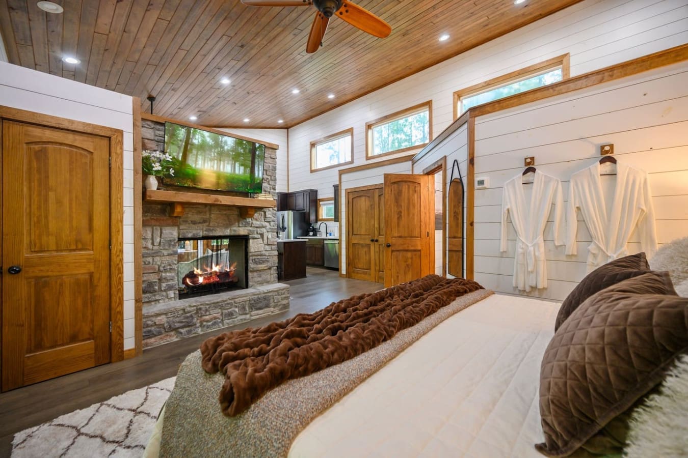 Wake up to a fireplace view, forest windows, and your own kitchenette—this master suite basically has everything you need to never leave bed (but you probably will, eventually).