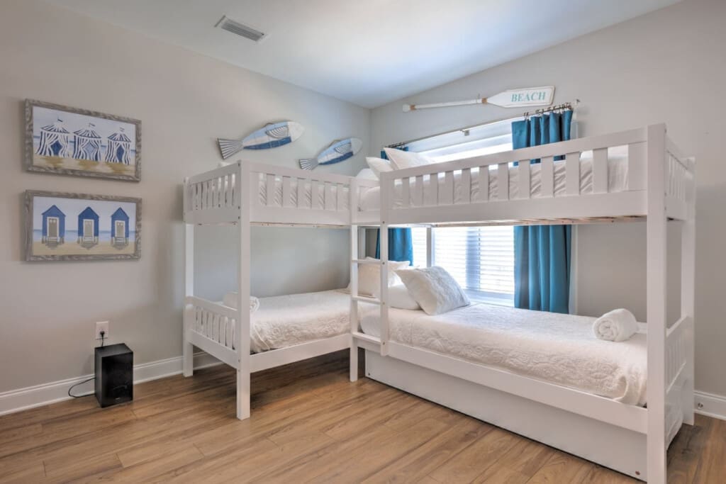 This kids' bedroom is basically a sleepover dream come true with four cozy bunks and enough beach vibes to make them forget all about their devices.