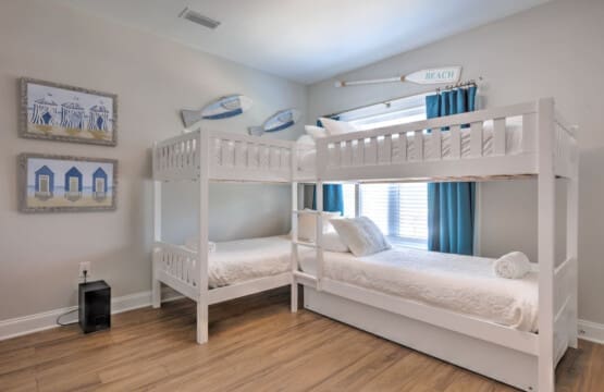 This kids' bedroom is basically a sleepover dream come true with four cozy bunks and enough beach vibes to make them forget all about their devices.