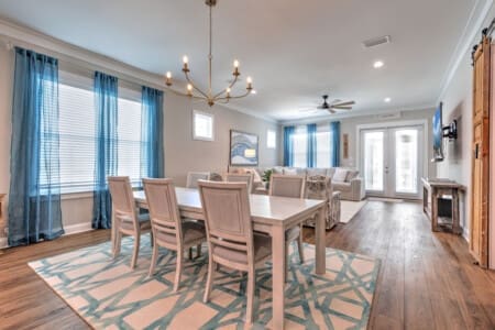 This open-concept space basically says "come hang out here" with the dining table, comfy seating, and those big bright windows all flowing together like the whole place was designed for people to actually gather and spend time together.