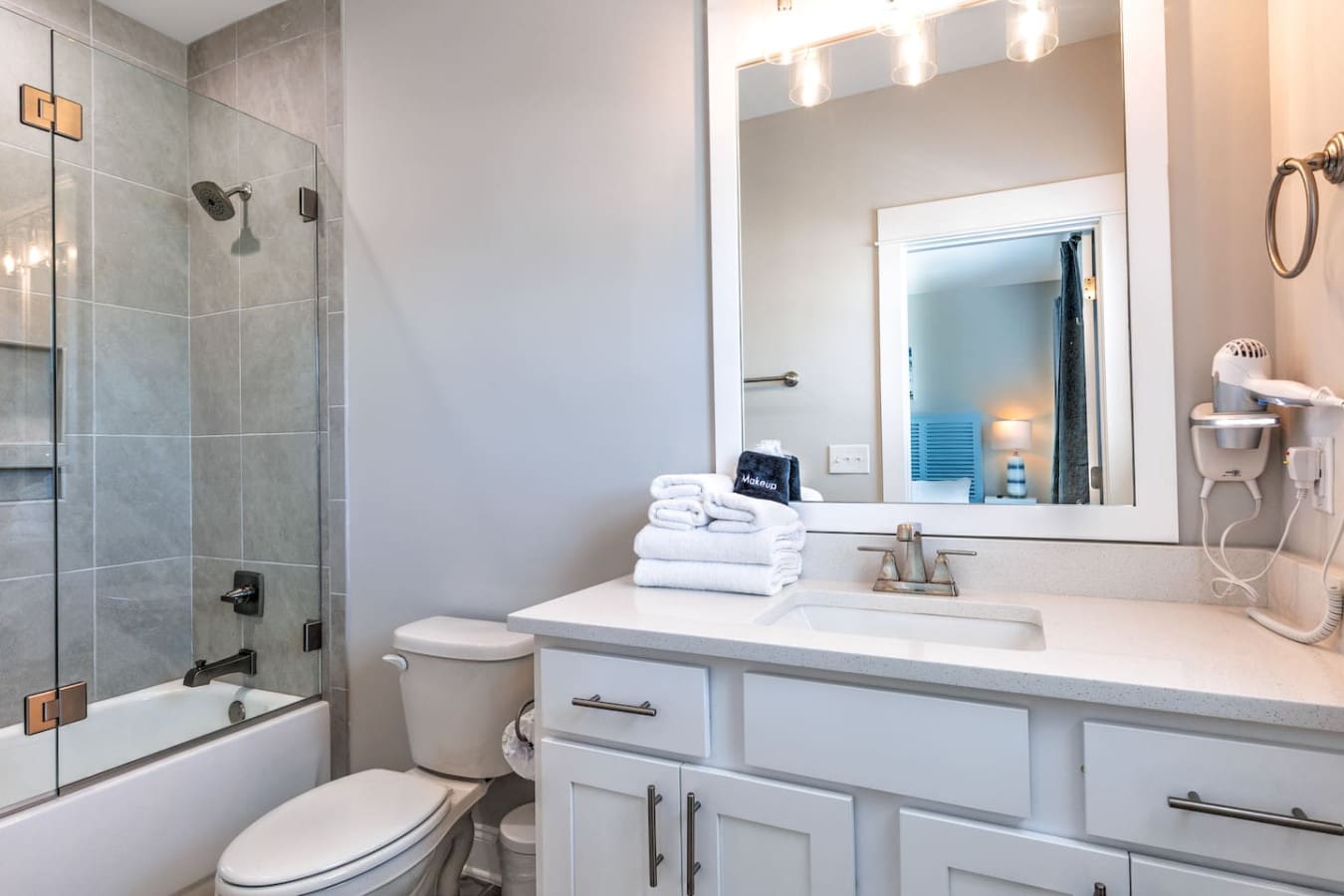 This bathroom is seriously the whole package—clean lines, a huge vanity with plenty of counter space, that gorgeous walk-in shower, and honestly just enough light and polish to make your morning routine feel way less painful.