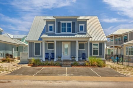 This modern farmhouse is giving major coastal charm with that crisp blue-and-white color combo and those inviting porches just begging you to kick back and watch the world go by.