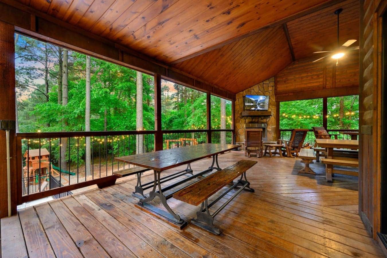 This screened-in game room lets you hang out around a ping pong table with a fireplace, a TV, and those forest views wrapping around you on every side—basically the ultimate spot to kill an afternoon without ever stepping outside.