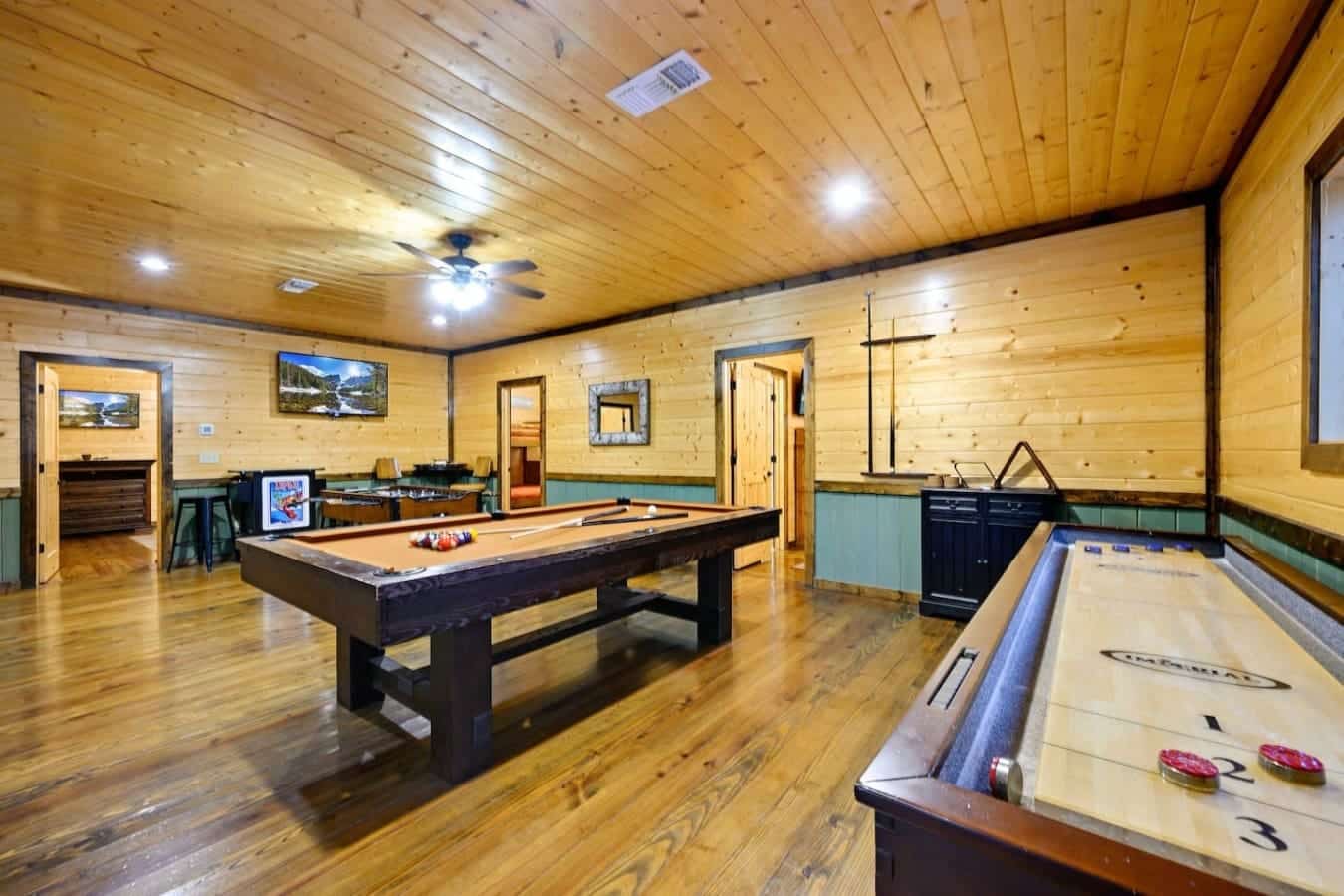 This game room is basically a playground for adults—pool table, shuffleboard, arcade games, and enough space that everyone can find something to do without getting in each other's way.
