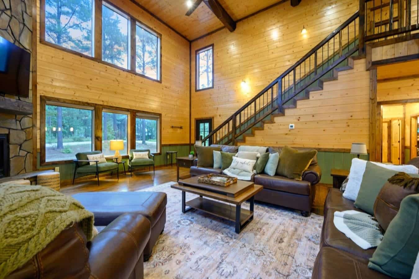 This main living room is basically what happens when you build a house that's all windows and wood beams and then fill it with enough seating for everyone to actually get comfortable at the same time.