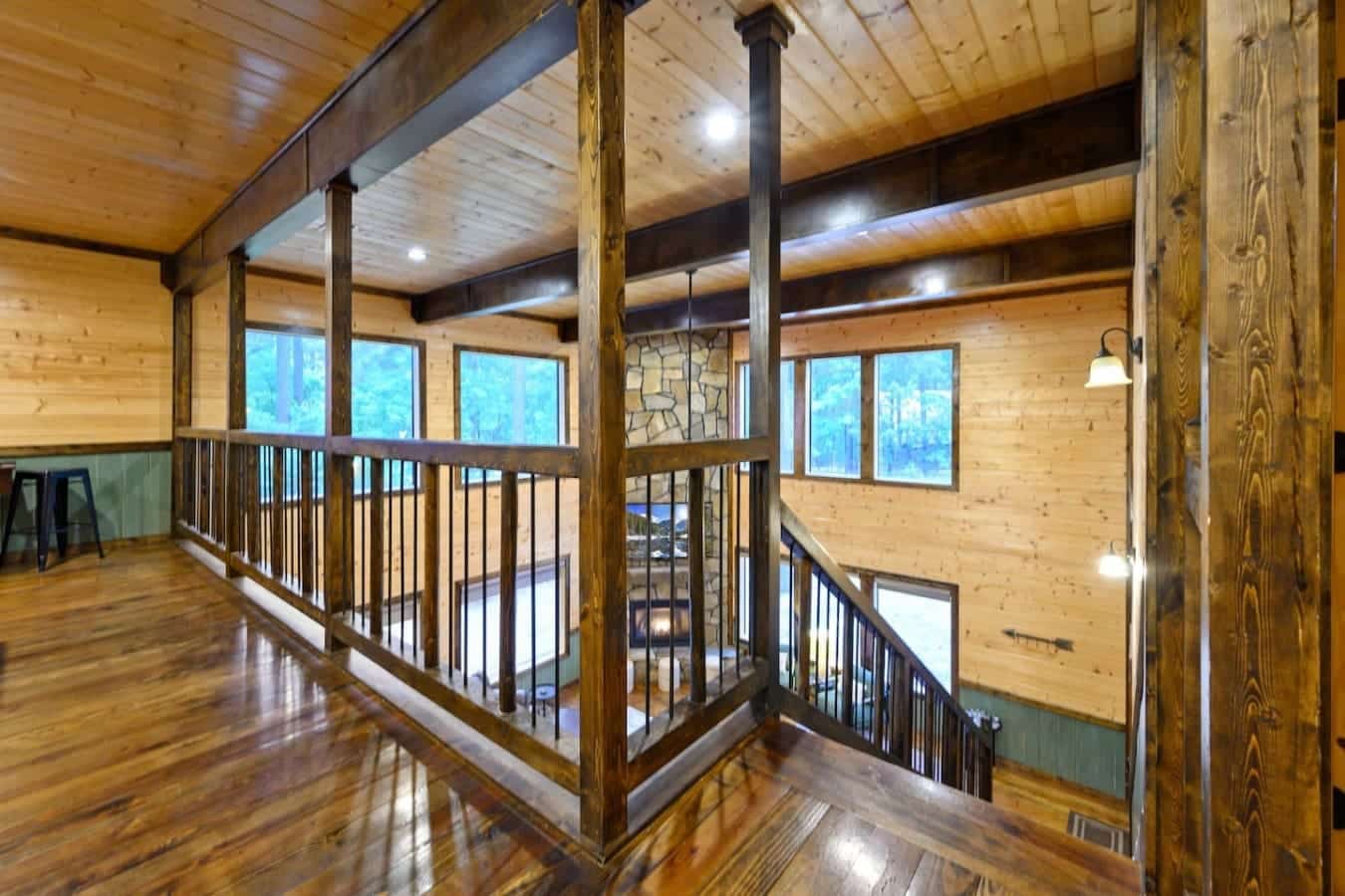 This upstairs loft walkway is basically the spine of the whole place—you can post up here with a book, keep an eye on everyone below, or just soak in the ridiculous amount of natural light streaming through all those windows.