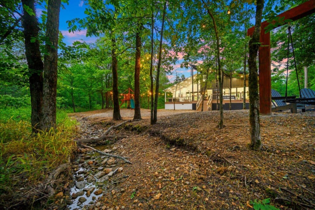 A forest playground, a babbling creek, and a swing under the trees—this cabin’s backyard is straight out of a storybook.