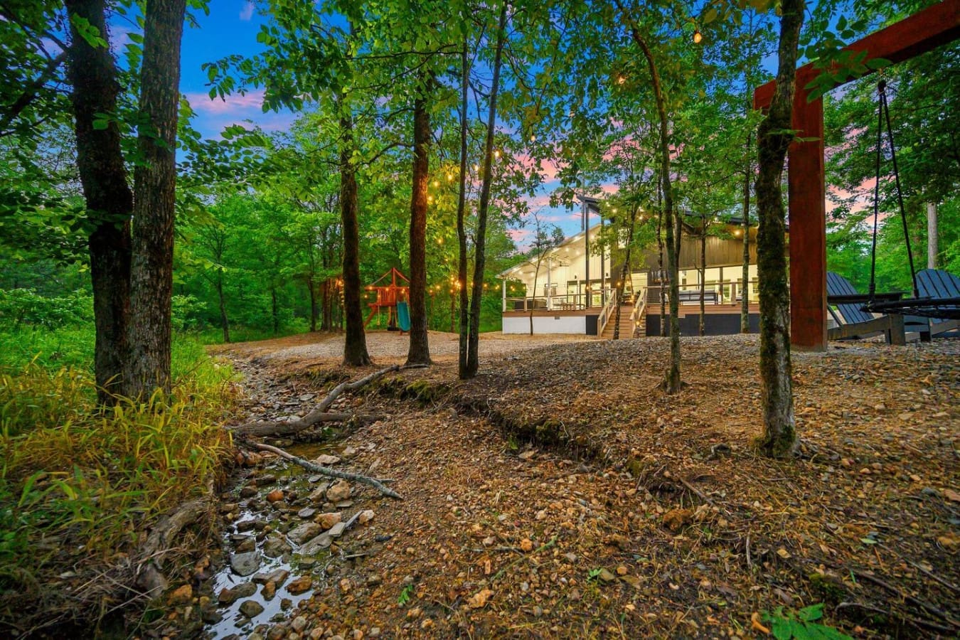 A forest playground, a babbling creek, and a swing under the trees—this cabin’s backyard is straight out of a storybook.