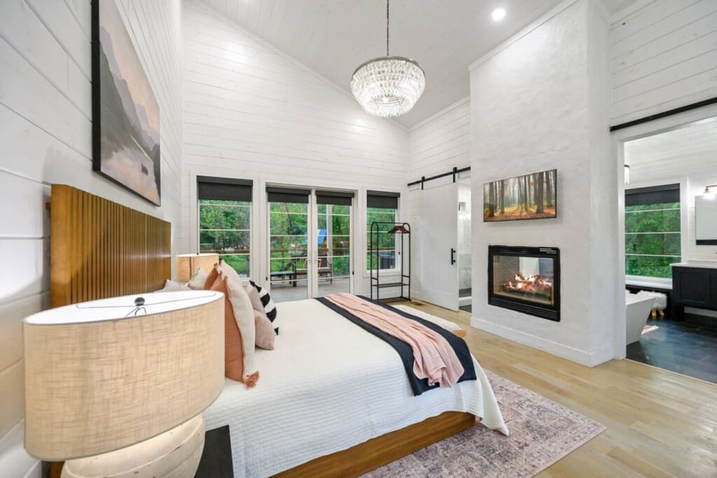 A dreamy cabin escape with fireside warmth and forest views right from bed.