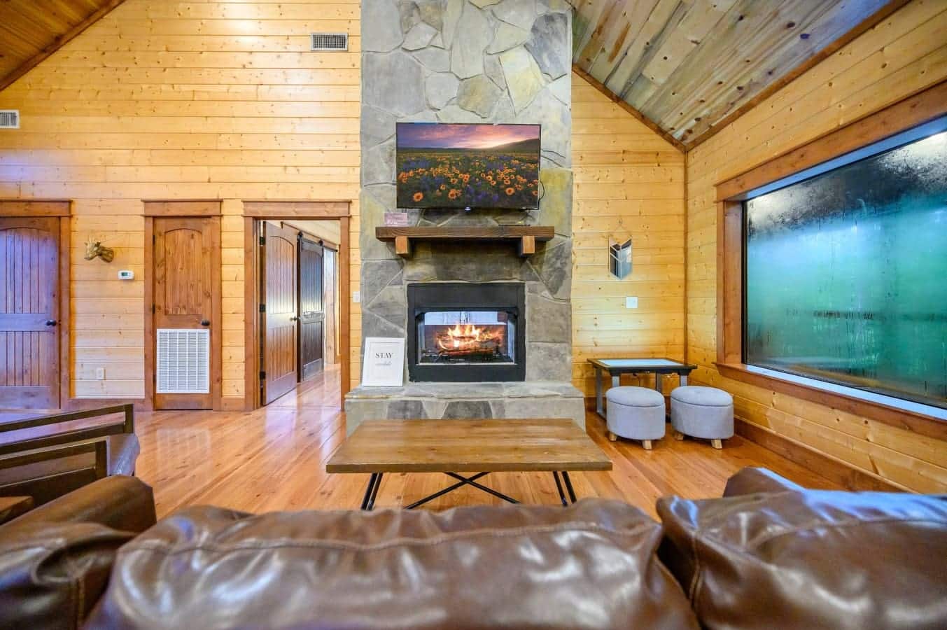 Large windows, cozy seating, and cabin charm throughout.