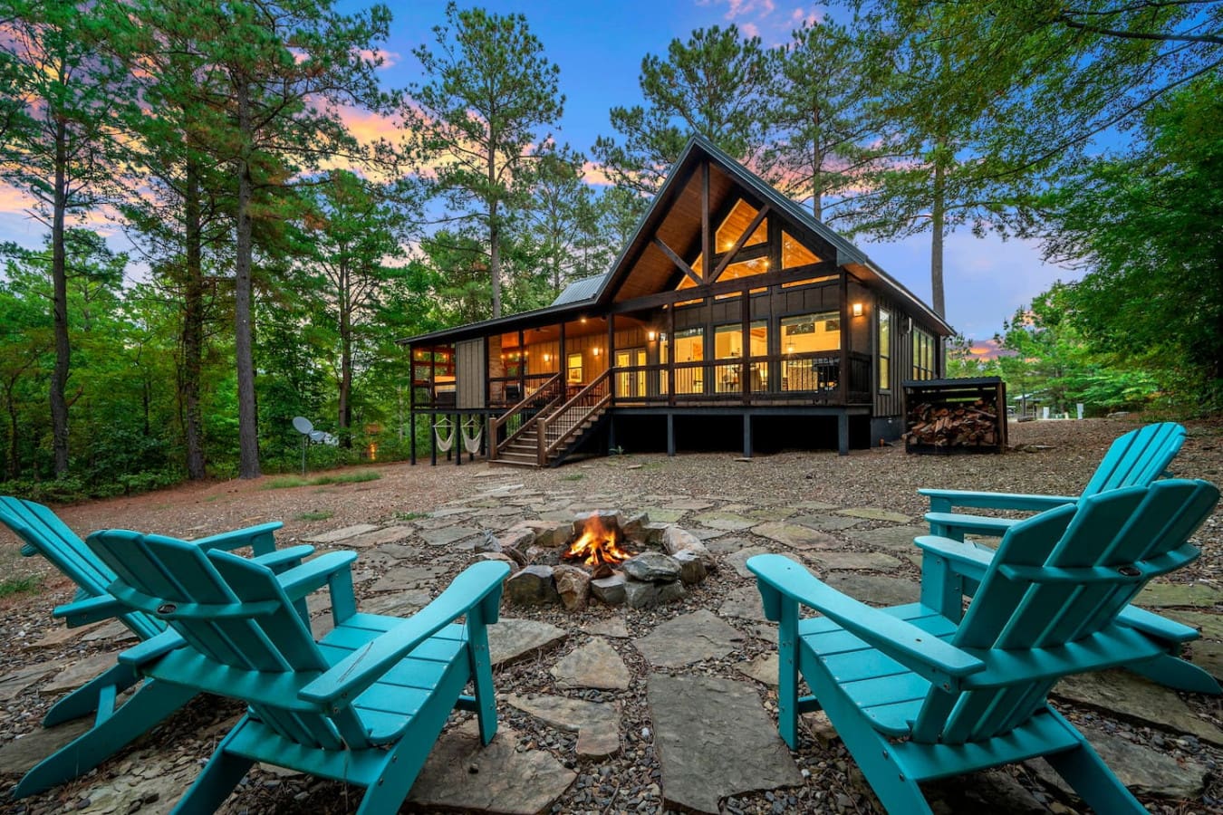 Grab a seat by the fire pit with those Adirondack chairs and you've basically got the perfect setup for laughing with friends under the stars while the cabin glows behind you.