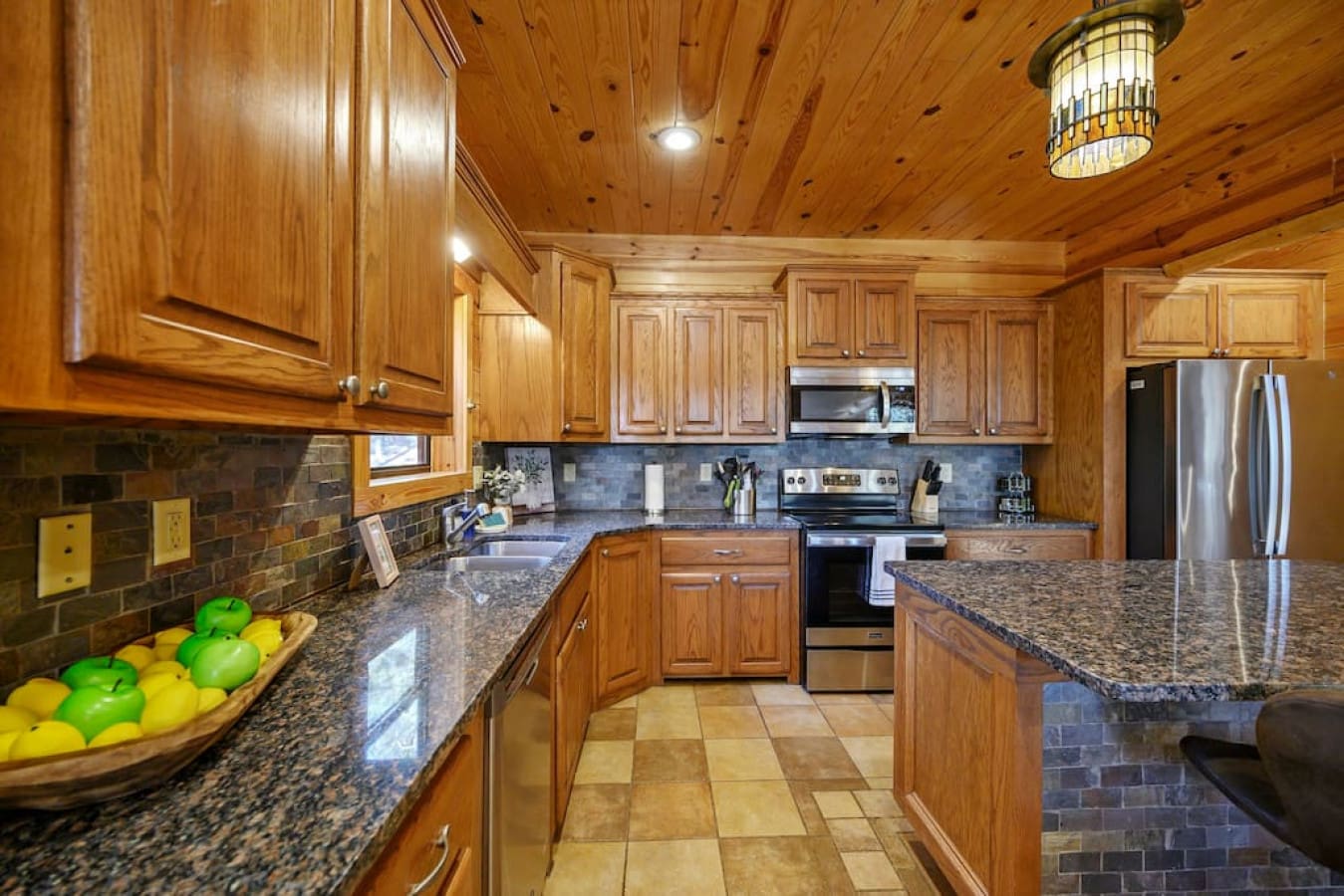 This kitchen is a bright and airy space, with gleaming countertops and all the appliances you need. The large island provides plenty of prep space and seating for casual meals.