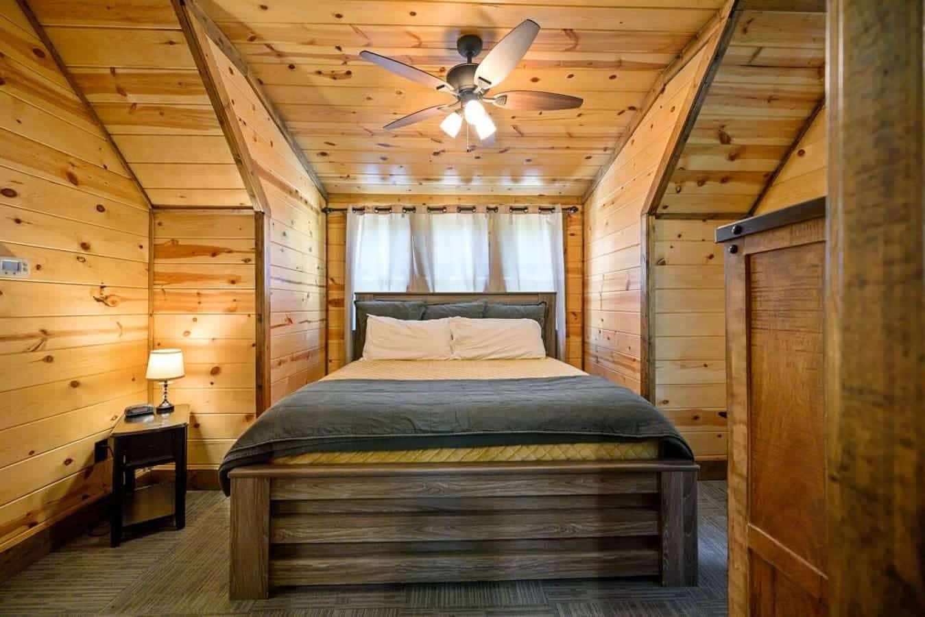 Sleep surrounded by the beauty of the wilderness in this cabin bedroom, where the outdoors seamlessly intertwines with the comfort of a restful night's sleep.
