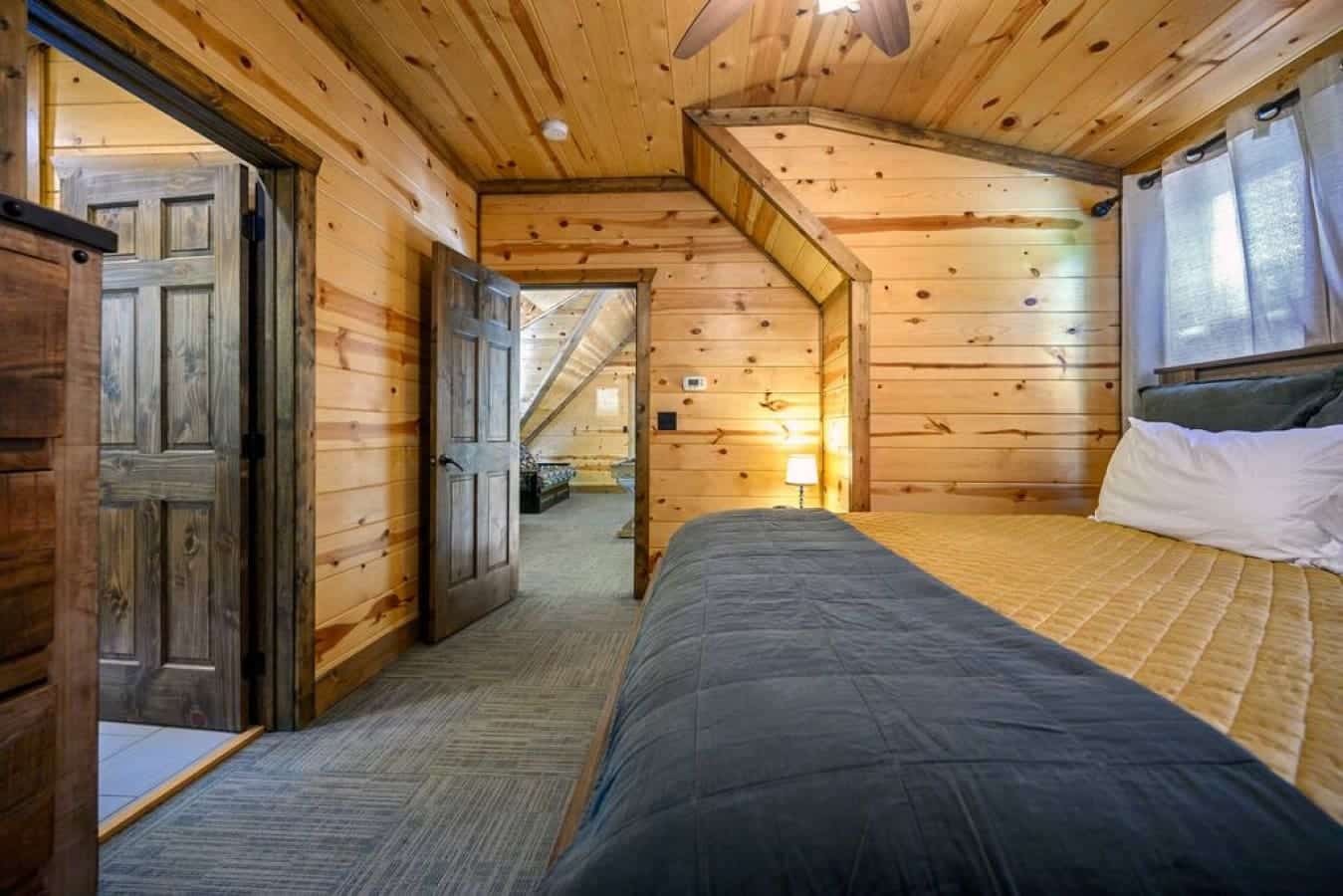 Experience the magic of a cabin night's sleep in this bedroom, where the rustic charm meets modern luxury for an enchanting retreat.