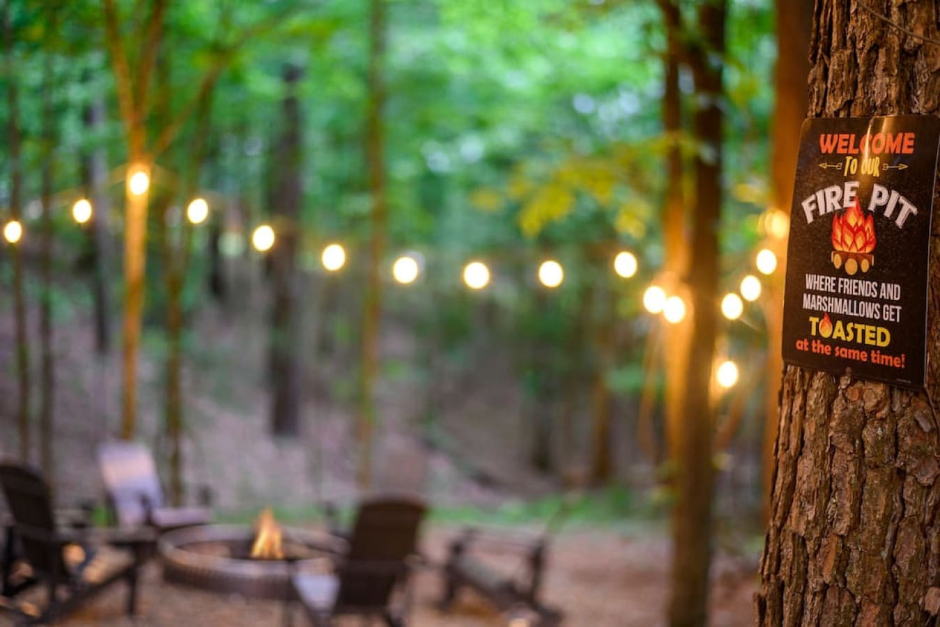 Gather 'round the glow: our cabin's fire pit under string lights.