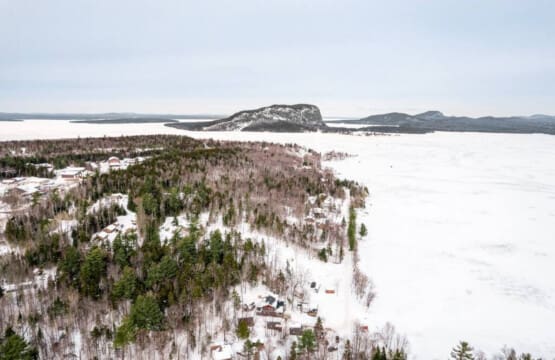 Picture your group spread across five cozy cabins with this stunning frozen lake and mountain view as your shared backyard.
