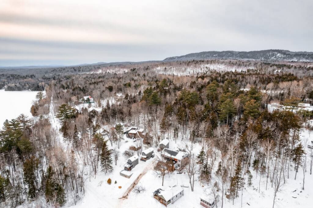 Wake up to snow-covered forests and mountains in every direction—this is what a real Maine winter wonderland looks like from your cabin doorstep.