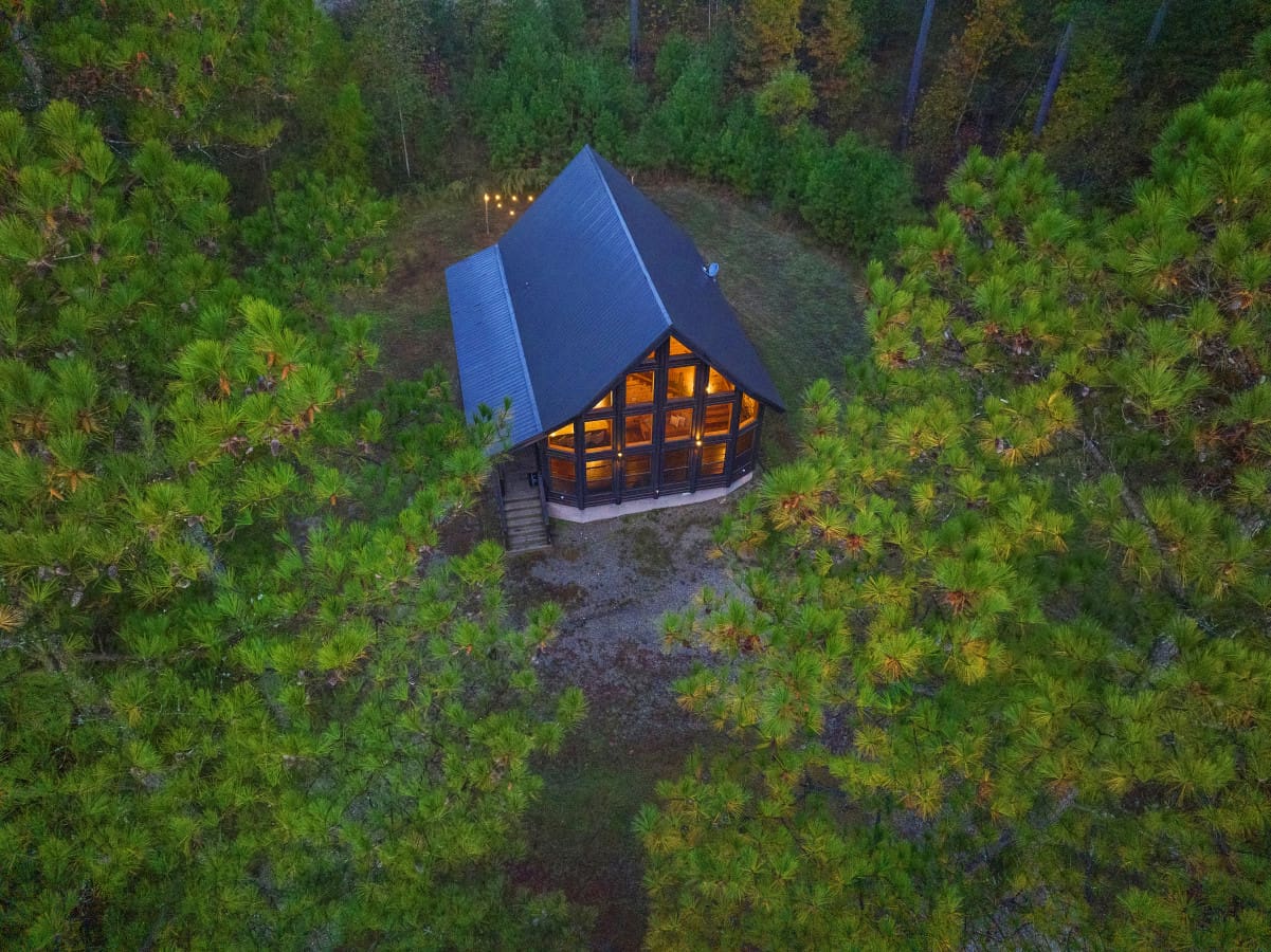 Aerial serenity, cabin nestled in nature's embrace.