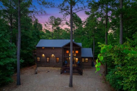 Embrace the serene beauty of nature with a picturesque front view of your cozy cabin.