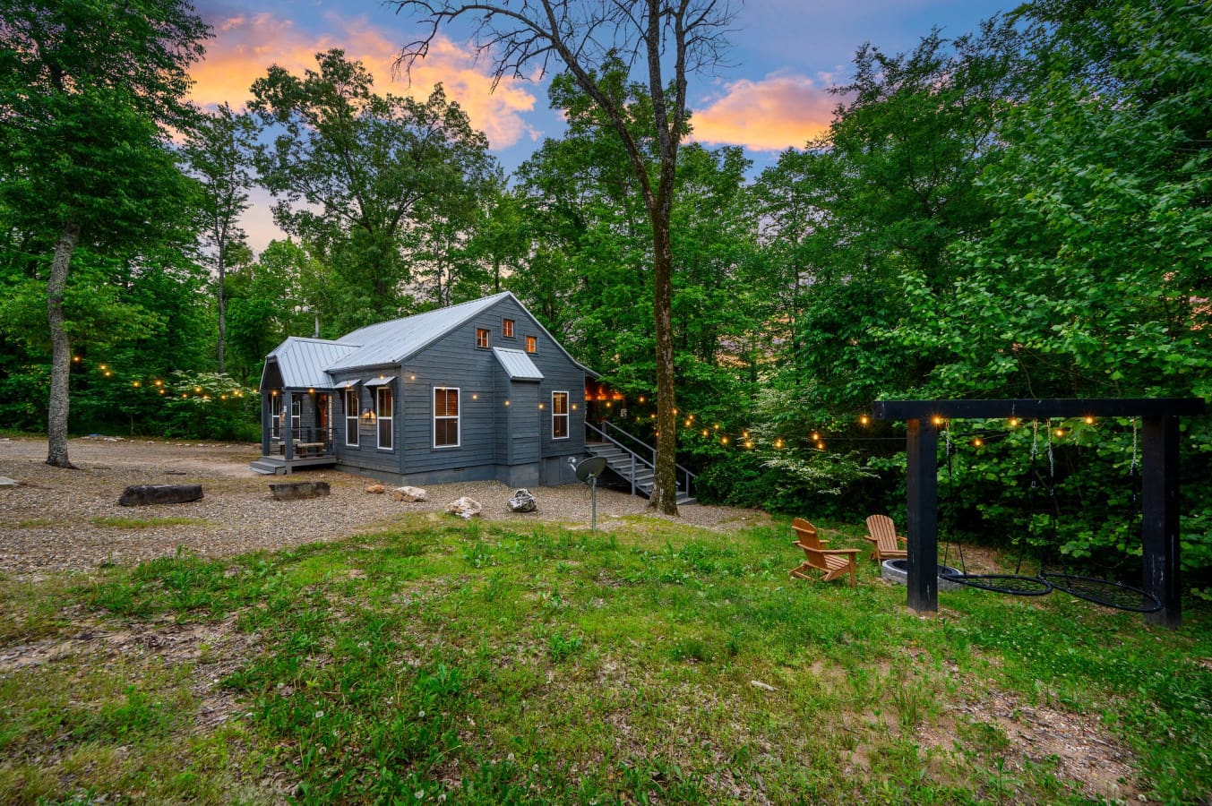 Side view of the property featuring a cozy firepit and warm string lights, creating the perfect setting for relaxing evenings outdoorsSide view of the property featuring a cozy firepit and warm string lights, creating the perfect setting for relaxing even