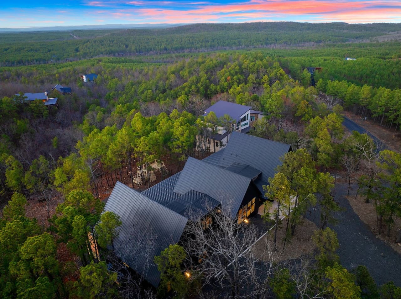 Nestled deep in the forest with those dramatic dark roofs and glowing windows, this modern retreat basically looks like the kind of hidden gem where you can disappear into nature without sacrificing a single design detail.