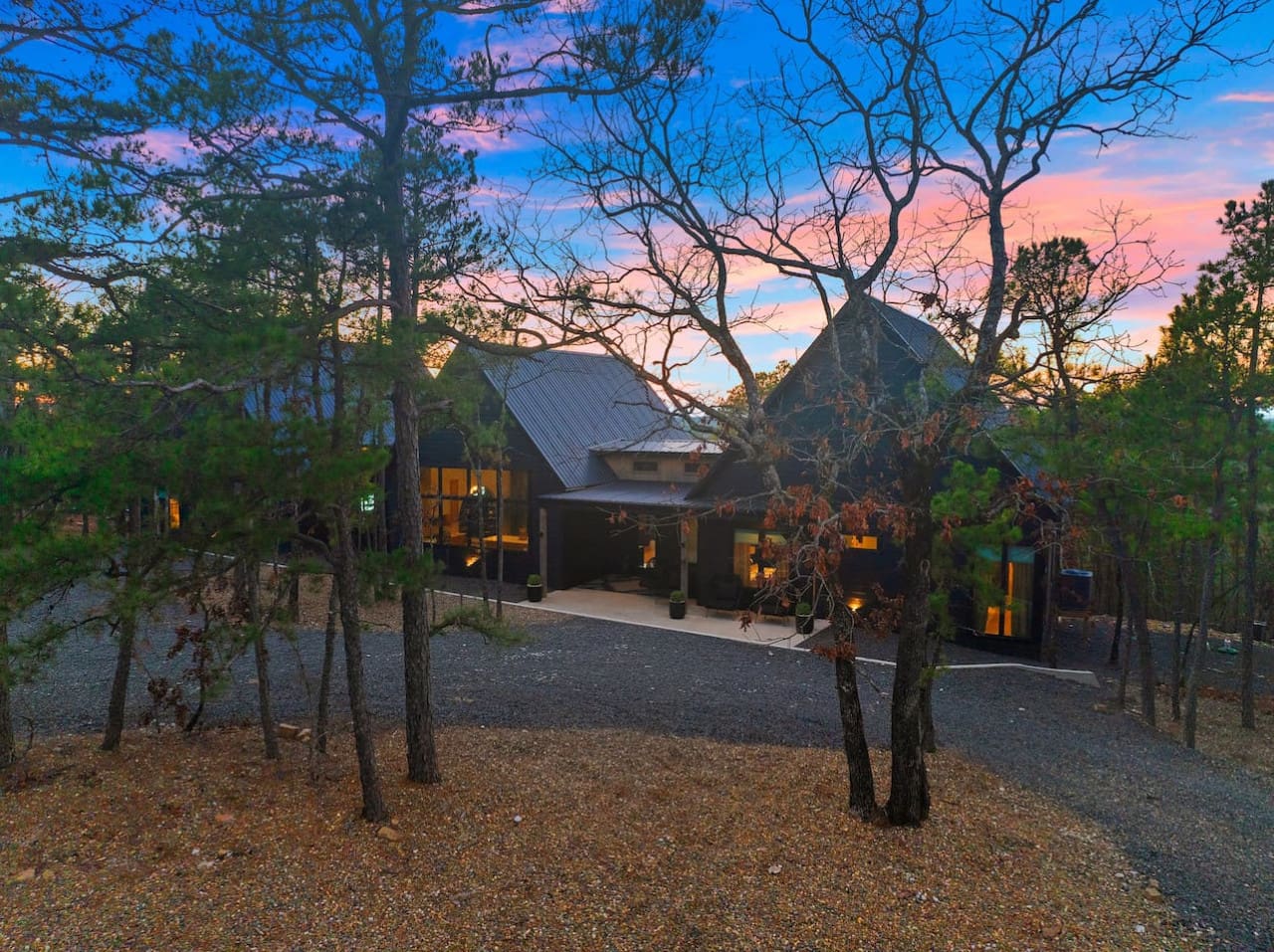 This modern architectural gem tucked into the pines with those dramatic peaked roofs and warm glowing windows basically looks like the perfect hideaway where you can watch the sky put on a show while surrounded by quiet forest vibes.