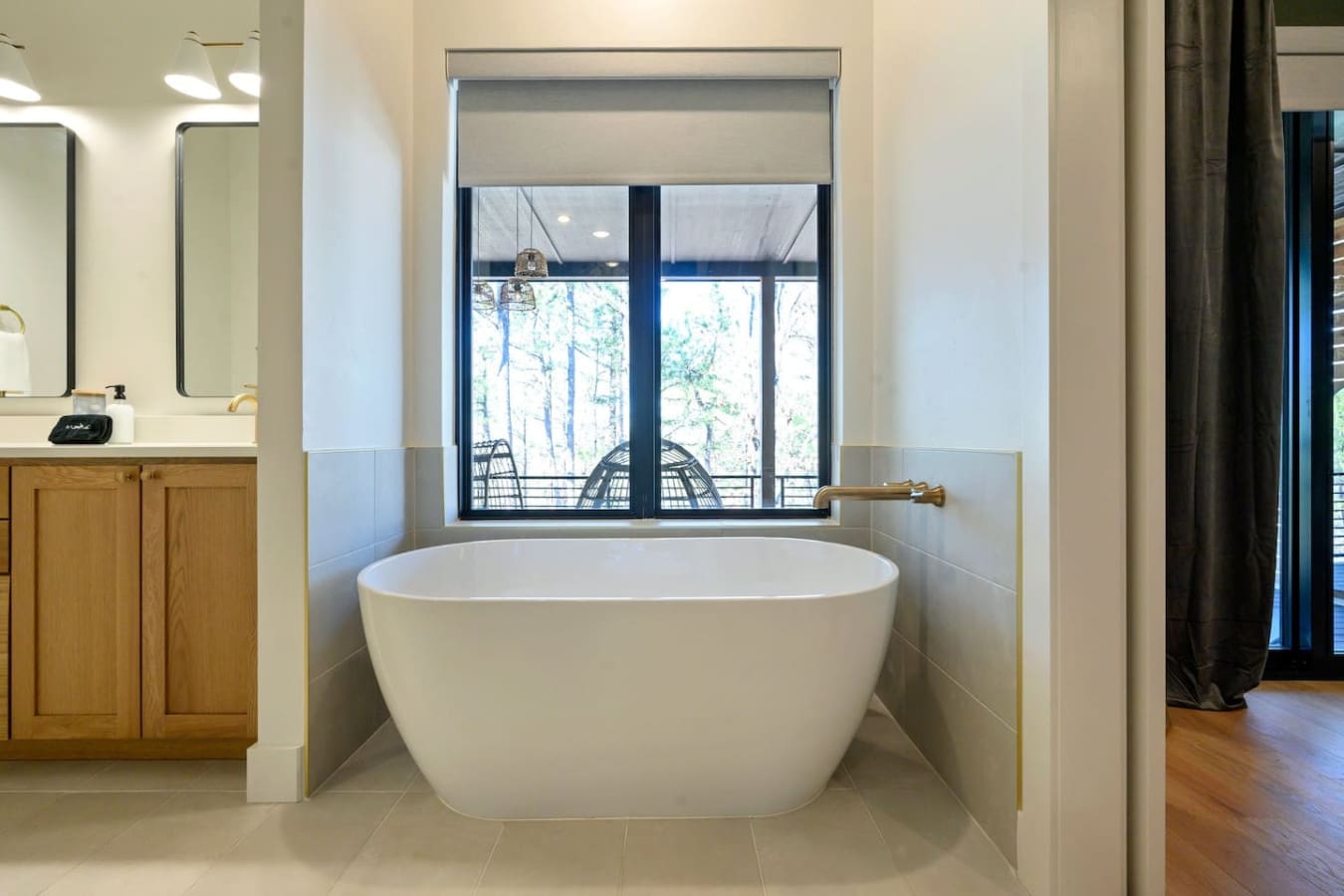 This freestanding soaking tub positioned right in front of those huge windows with forest views is basically the definition of a peaceful retreat—fill it up, sink in, and zone out while gazing at the trees.