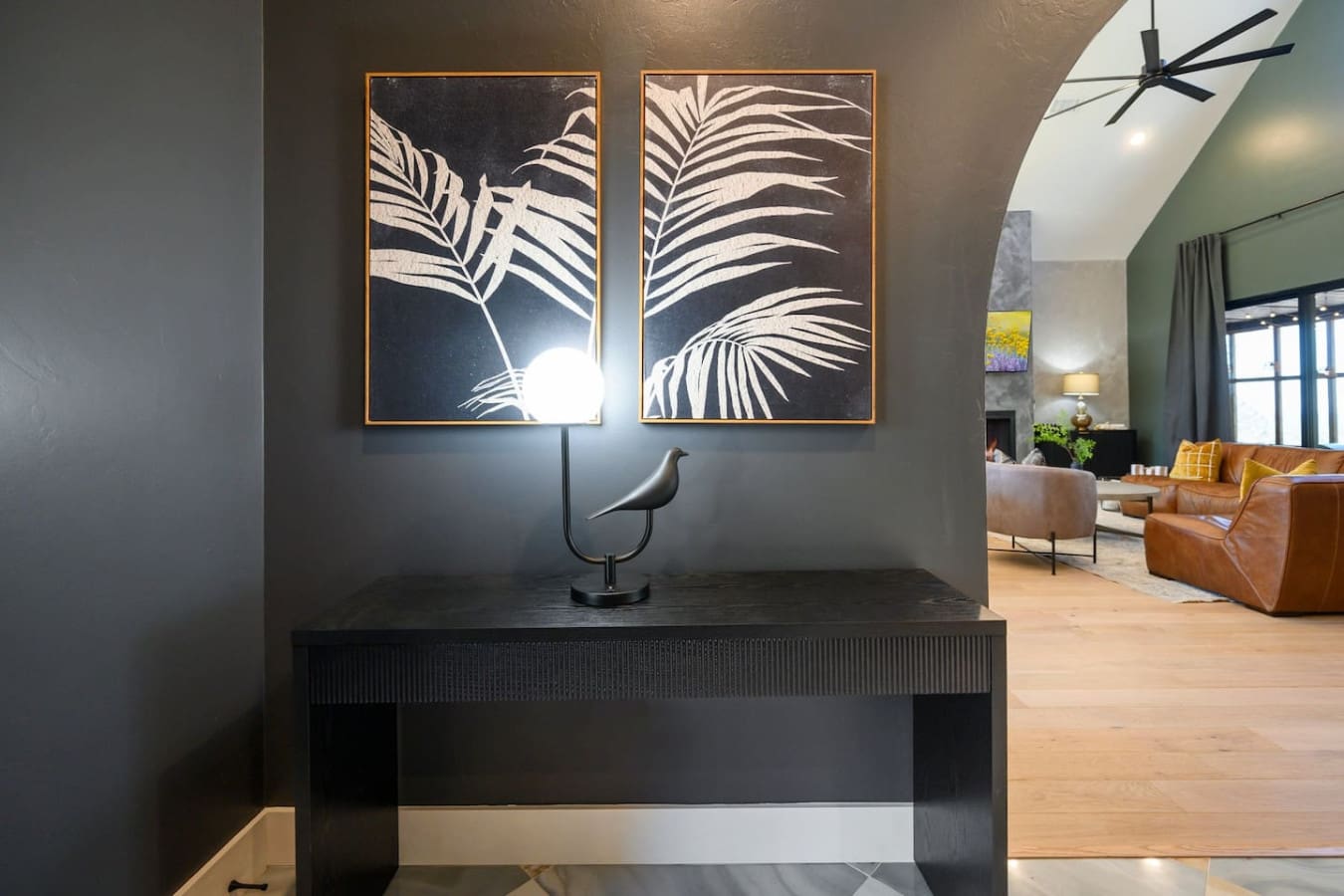 This entryway hits different with those two striking botanical prints, moody dark walls, and that sculptural bird lamp that basically sets the tone for a stay that's equal parts sophisticated and totally Instagram-worthy.