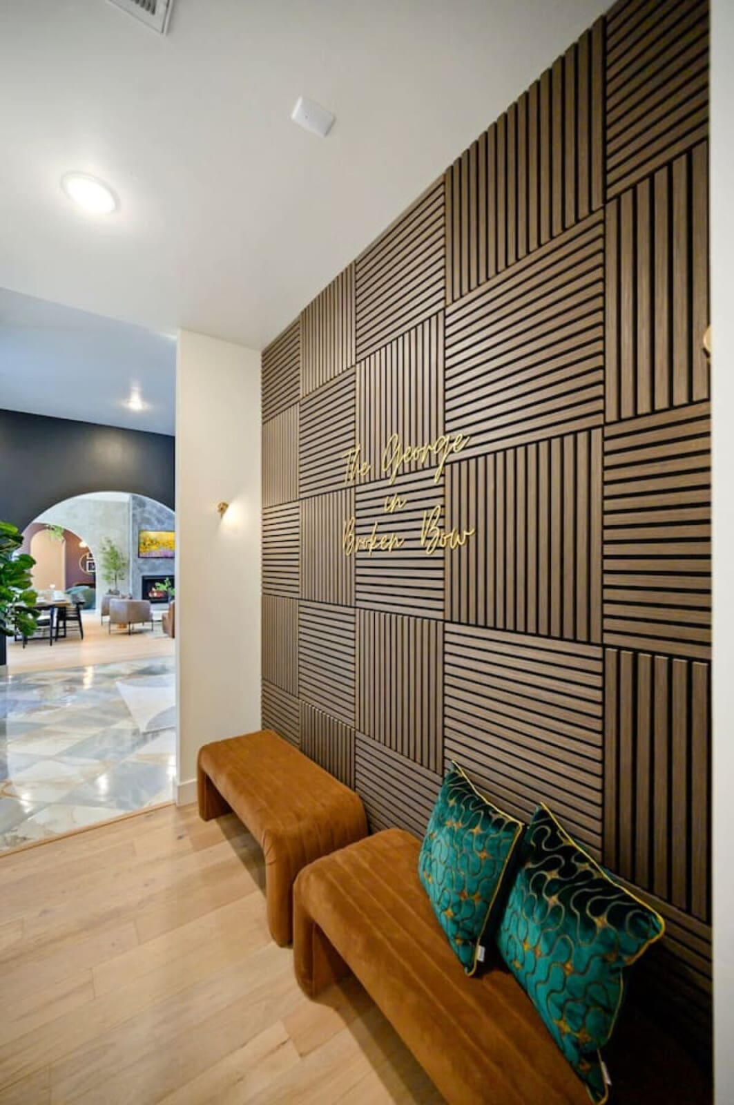 This sleek entryway with those gorgeous geometric wood wall panels and gold neon signage basically sets the tone for the whole place—modern, thoughtfully designed, and totally Instagram-worthy before you even step inside.