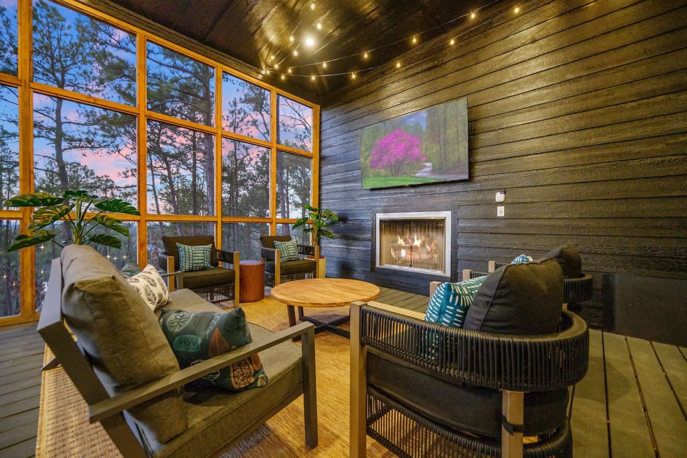 This cozy living room wrapped in windows and warmed by a fireplace is basically the perfect setup for those nights when you want to curl up by the fire, watch the forest fade into darkness, and pretend the rest of the world doesn't exist.