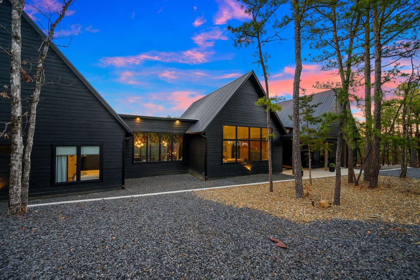 This sleek modern compound nestled deep in the pines with those dramatic peaked roofs basically looks like the kind of architectural escape where you can watch the sky turn pink and gold while feeling completely wrapped up in the forest quiet.