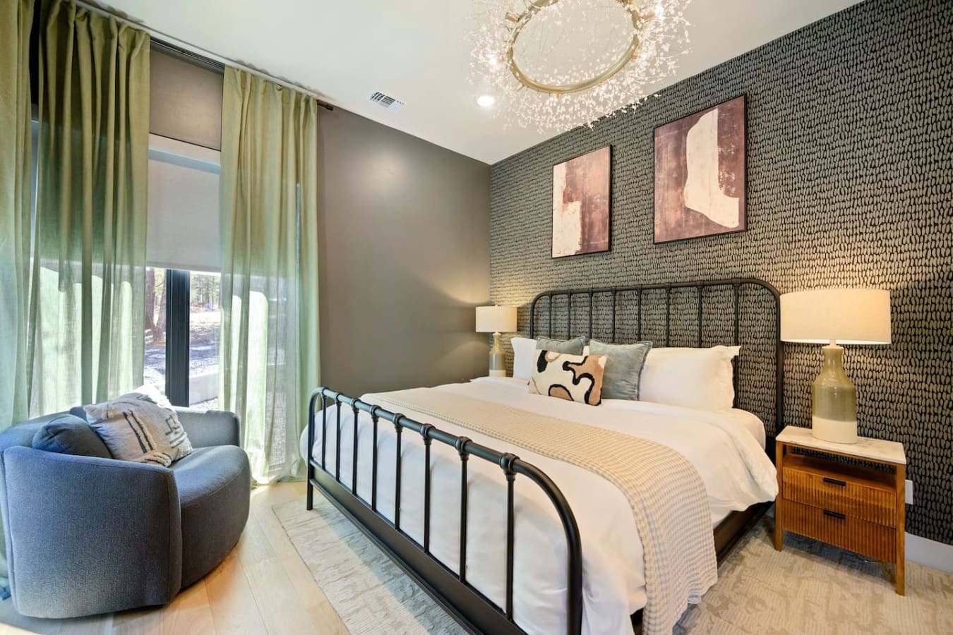 This bedroom totally nails the modern elegance thing with that textured accent wall, sleek black metal bed, the sparkling crystal chandelier overhead, and those warm touches that make it feel like a sophisticated retreat without losing that cozy, inviting