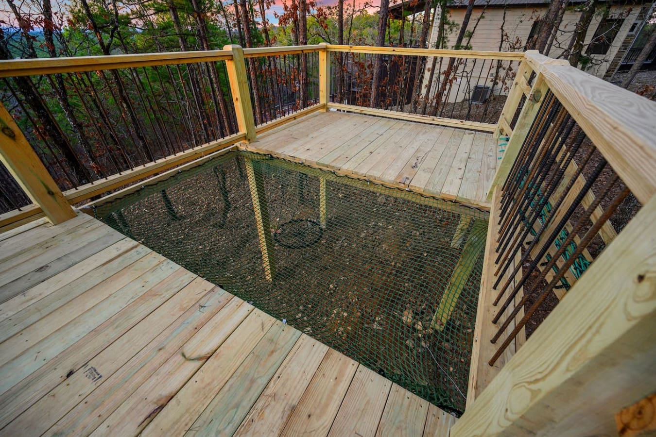This deck literally has a built-in net that drops down into the forest below, which is basically the coolest way to make sure your outdoor space stays pest-free while you're soaking in those tree-canopy views.