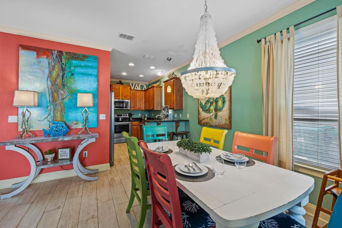 This dining room is basically proof that vacation doesn't have to be boring—colorful chairs, that stunning beaded chandelier, and walls in coral and seafoam green come together to make every meal feel like a celebration.