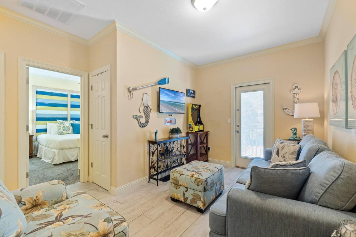This cozy living area is basically the perfect setup for lazy afternoons and people-watching—comfy seating, that adorable patterned ottoman, and direct access to the outdoors so you can bounce between indoor chill time and whatever adventure calls you out