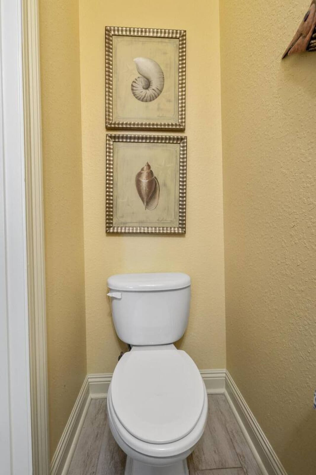 Even this tiny powder room gets the full personality treatment with those cheerful yellow walls and shell-themed art that basically remind you that you're in the cutest little beach escape ever.