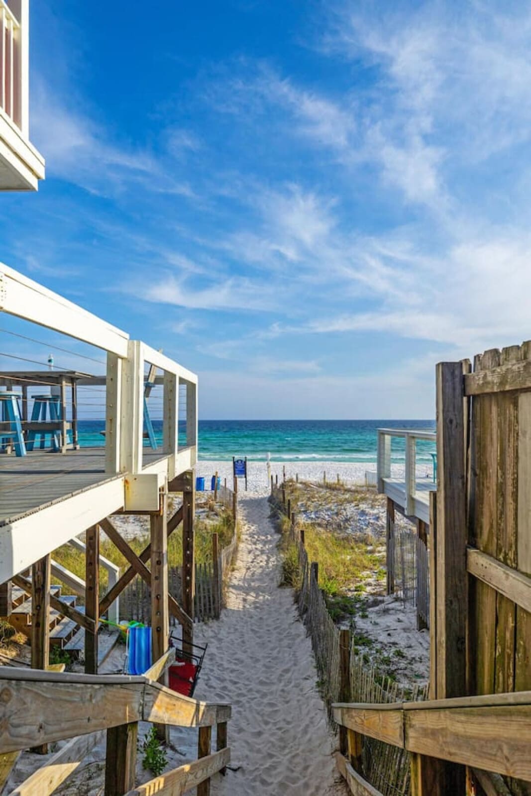 The sandy pathway framed by those weathered wooden gates is basically your personal red carpet to the ocean—complete with dune grasses, that perfect stretch of beach, and the kind of view that makes you forget why you ever left.