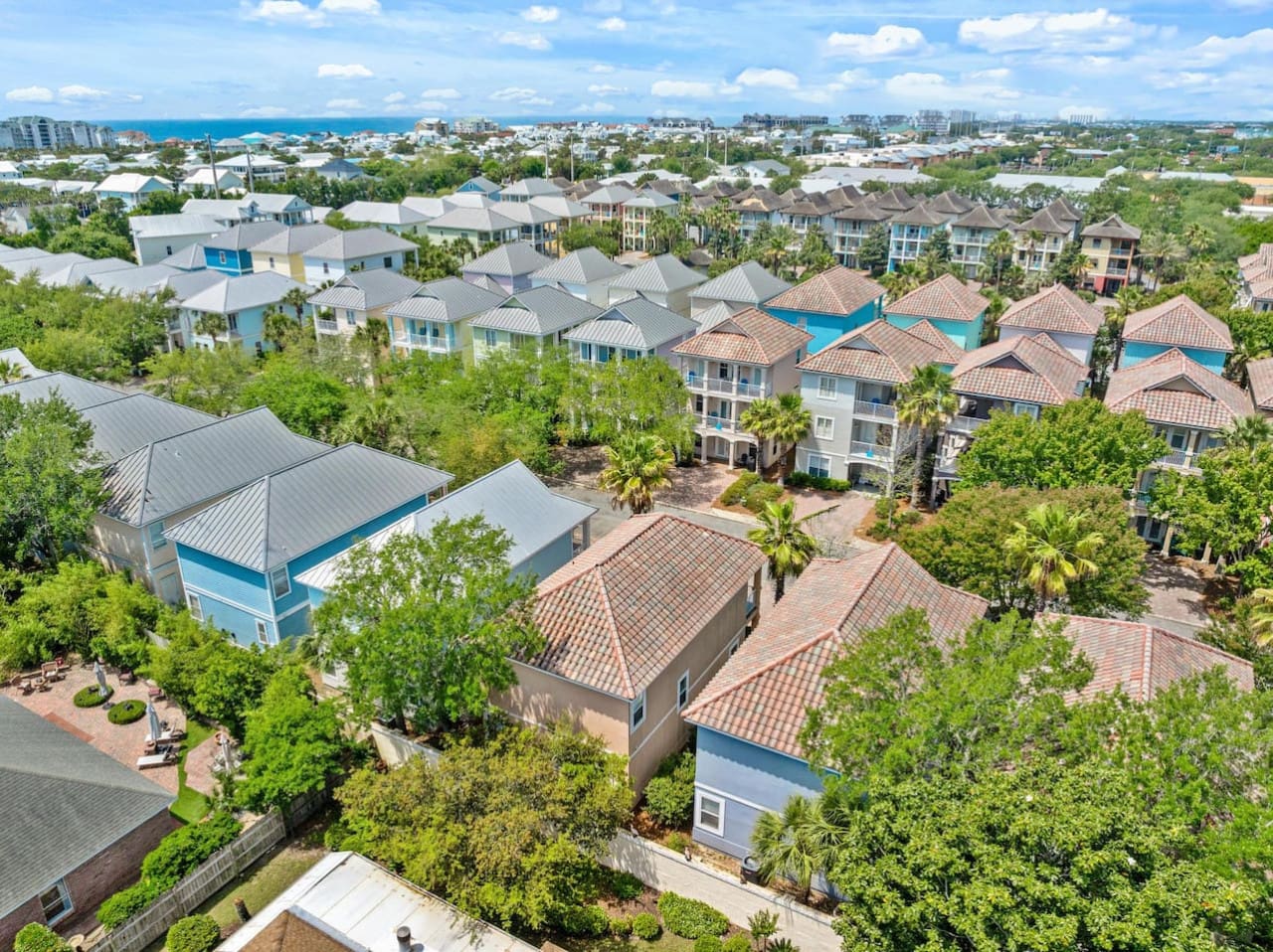 This aerial view shows you exactly why this neighborhood is so ridiculously perfect—you're nestled right in the heart of a tree-shaded, pool-dotted community that's basically your own little beach town escape without ever feeling crowded.