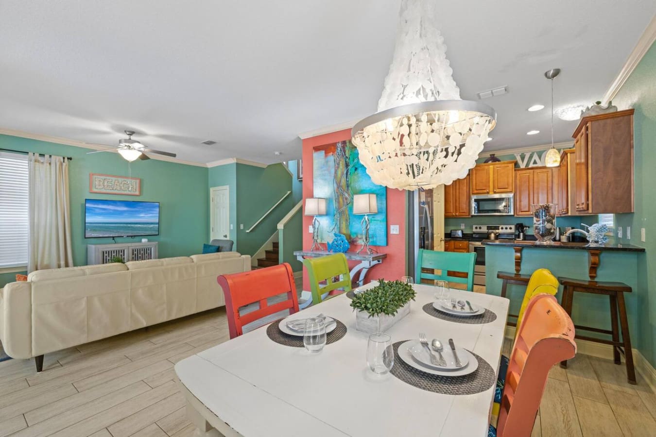 This open-concept living space basically proves that a colorful palette and thoughtful layout can turn a vacation rental into the kind of place where you actually want to spend all your time—whether you're dining, cooking, or just soaking in those good vi