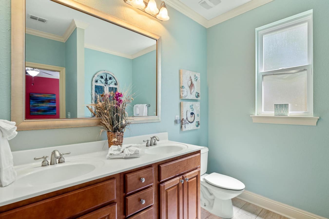 The dual vanity setup in this guest bathroom is basically the perfect setup for getting ready without any morning bathroom negotiations—plenty of space, that gorgeous seafoam color scheme, and those charming nautical touches to keep the good vibes flowing