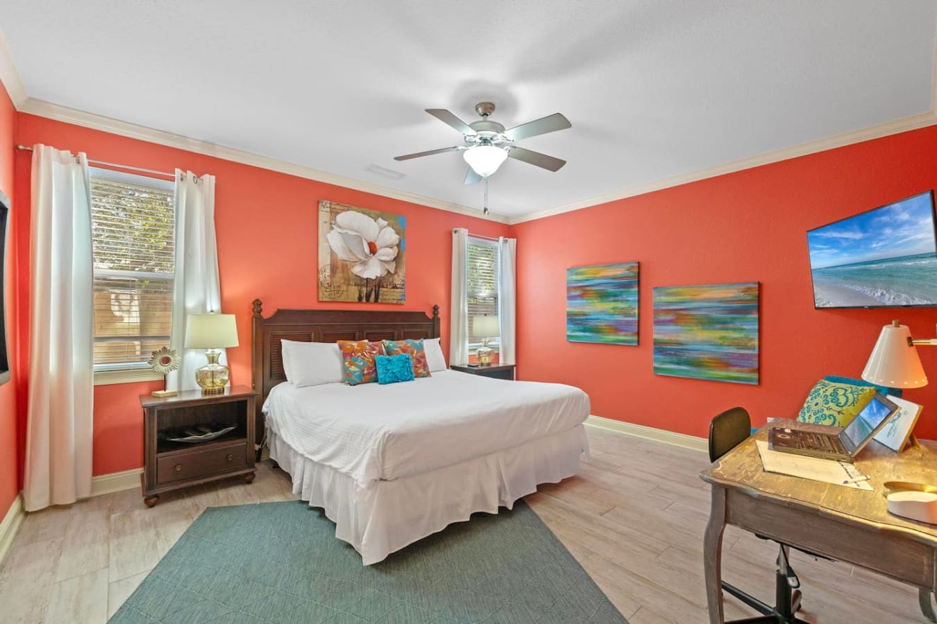 This coral bedroom is basically a burst of island energy—vibrant walls, colorful beach art, and that perfectly styled desk spot that somehow makes you want to both nap and get stuff done at the same time.