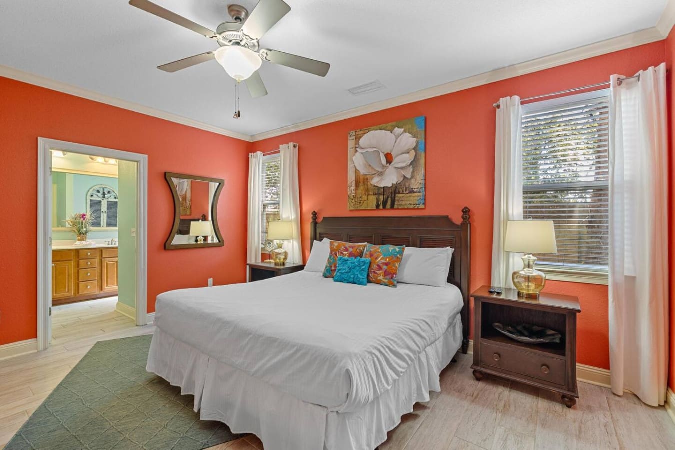 This master bedroom is basically a shot of pure vacation energy—those vibrant coral walls, colorful accent pillows, and that perfect blend of comfort and style basically guarantee you'll wake up smiling every single morning.