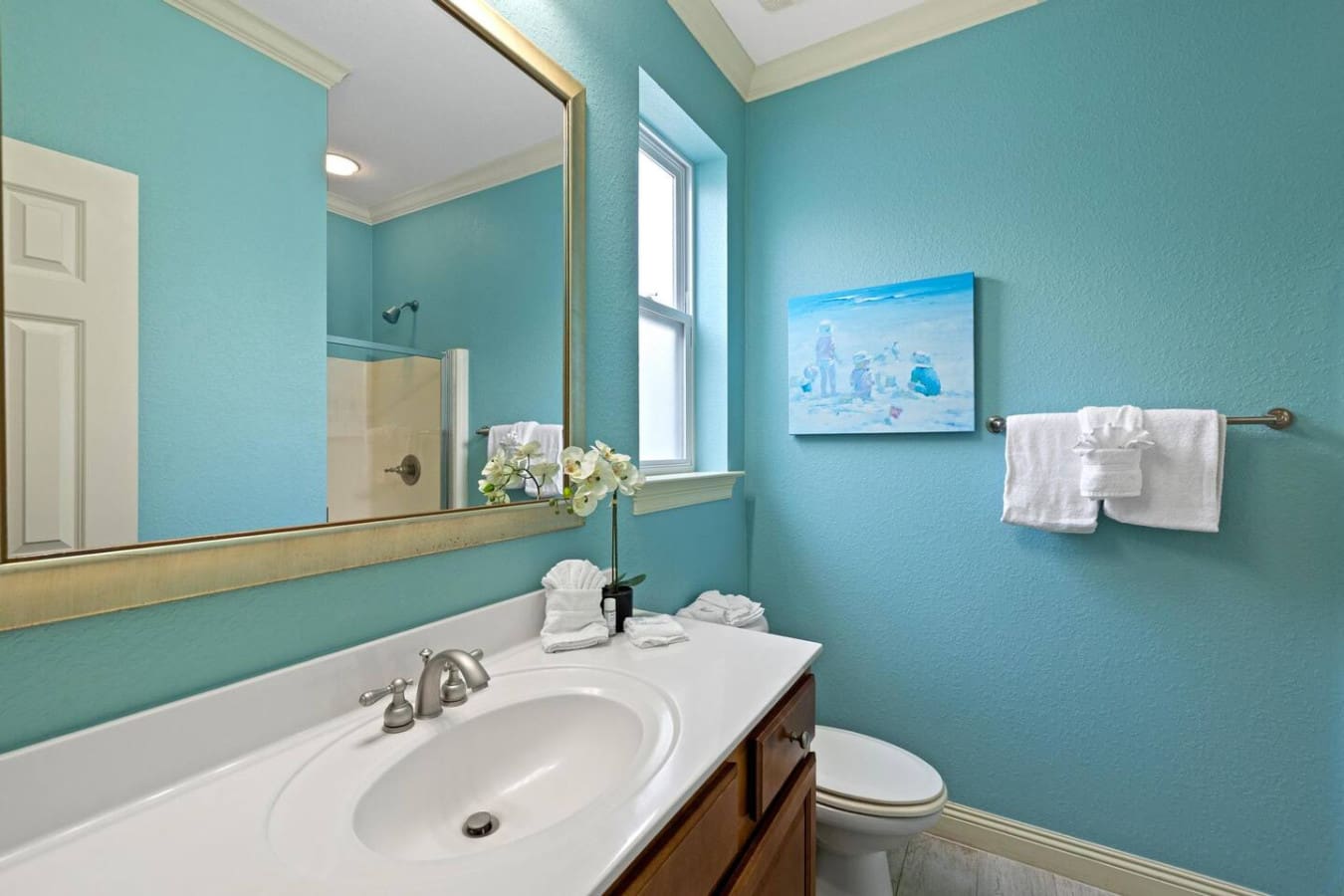 This turquoise bathroom is basically the perfect place to wash off the day—bright, clean, and so refreshingly cute that you'll actually want to linger over the details.